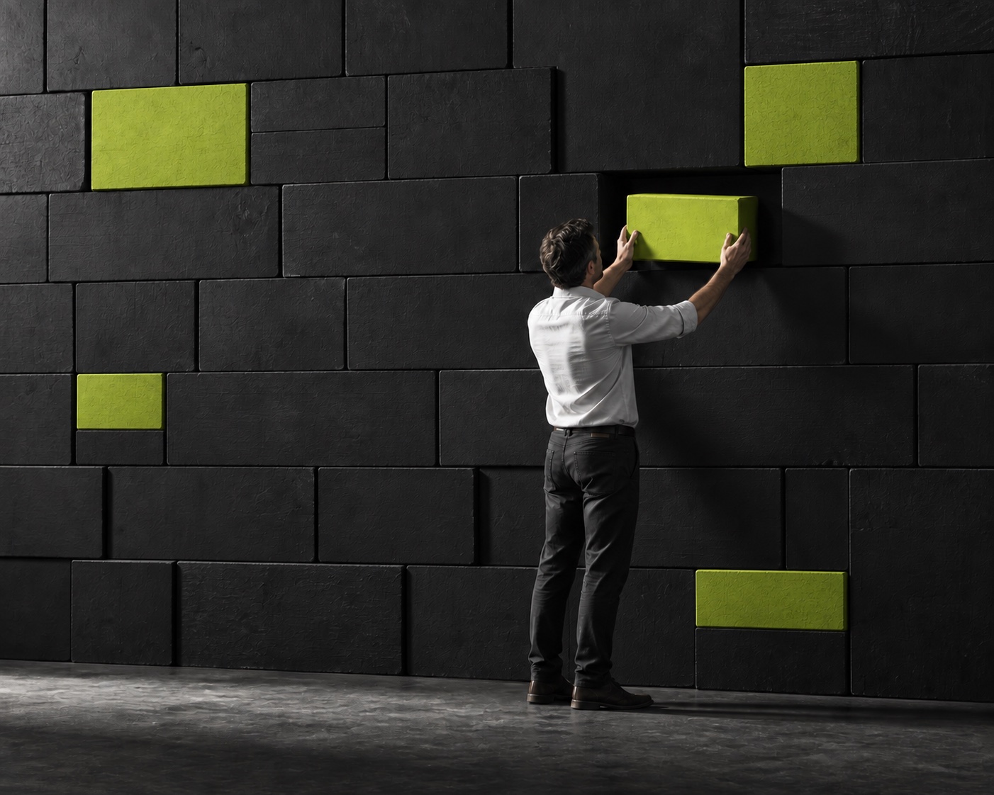 A person placing a lime block into a dark wall where other lime blocks are already integrated